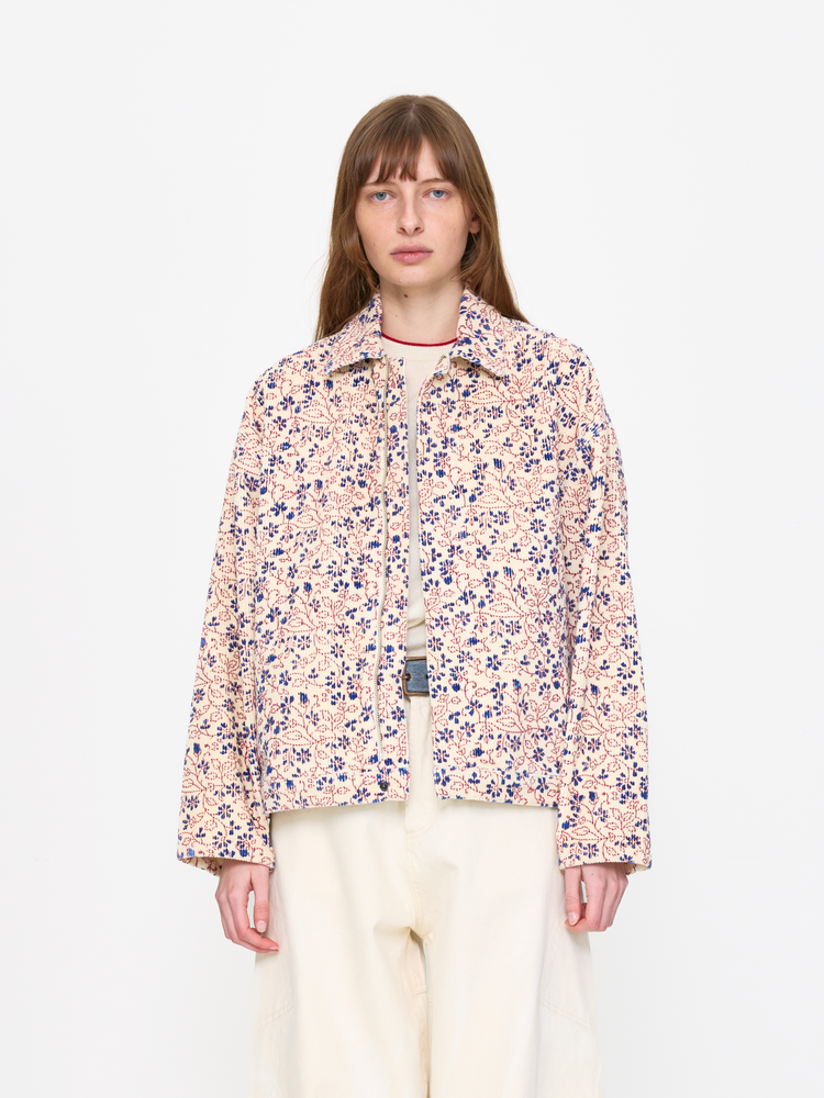 Person wearing a floral jacket on a white background