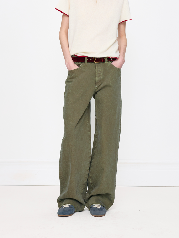 Person wearing green wide-leg pants and a white shirt on a white background